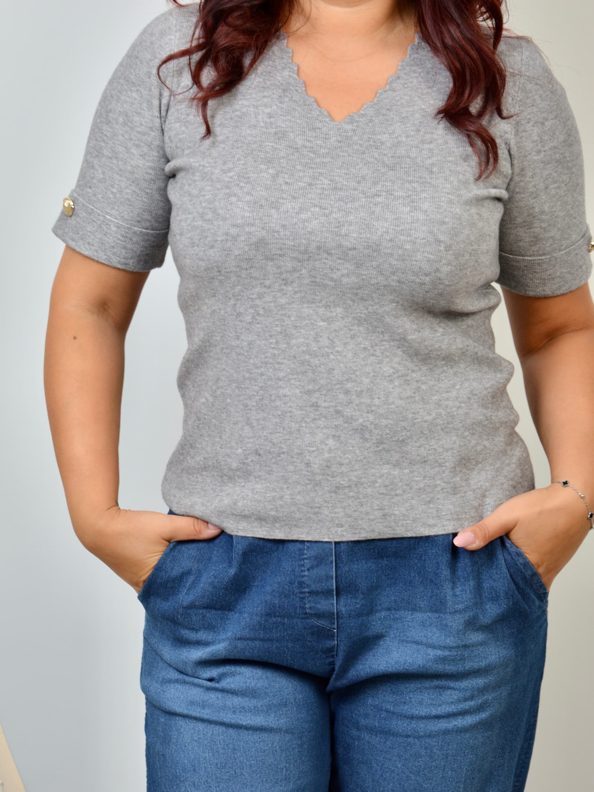 Sweter z ozdobnym dekoltem i złotym guzikiem